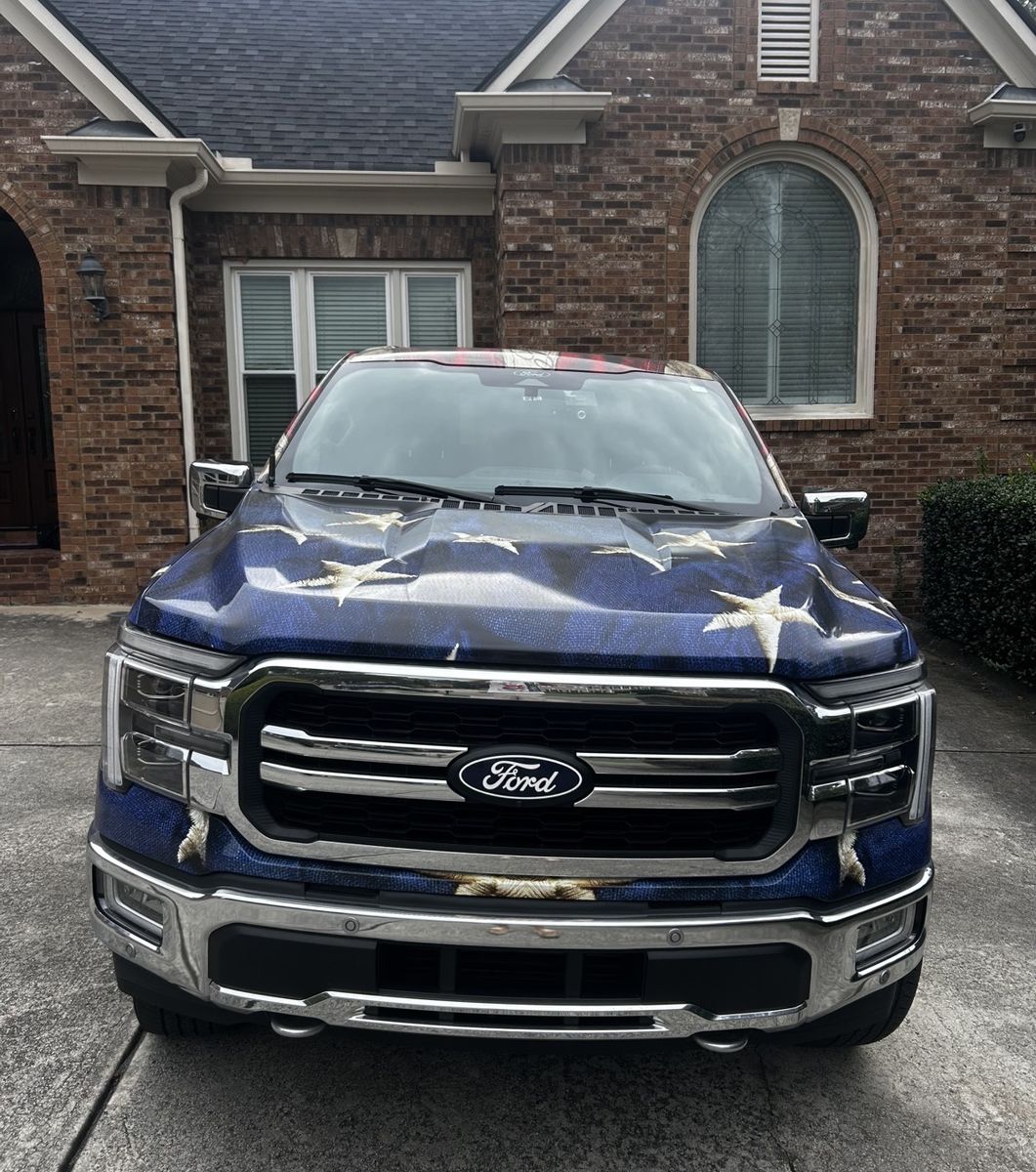 Ford F-150 with an American flag hood wrap, detailed on a brick driveway