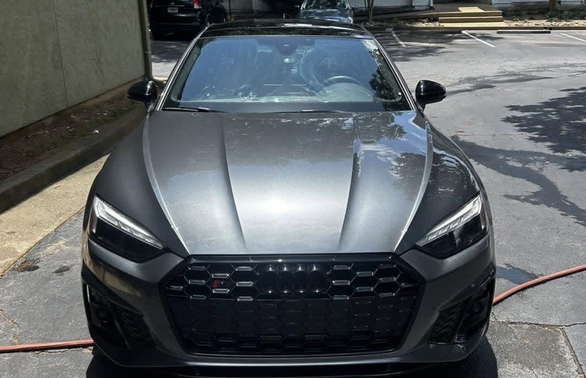 Grey Audi S5 photographed head-on after a full exterior detail in an apartment parking lot